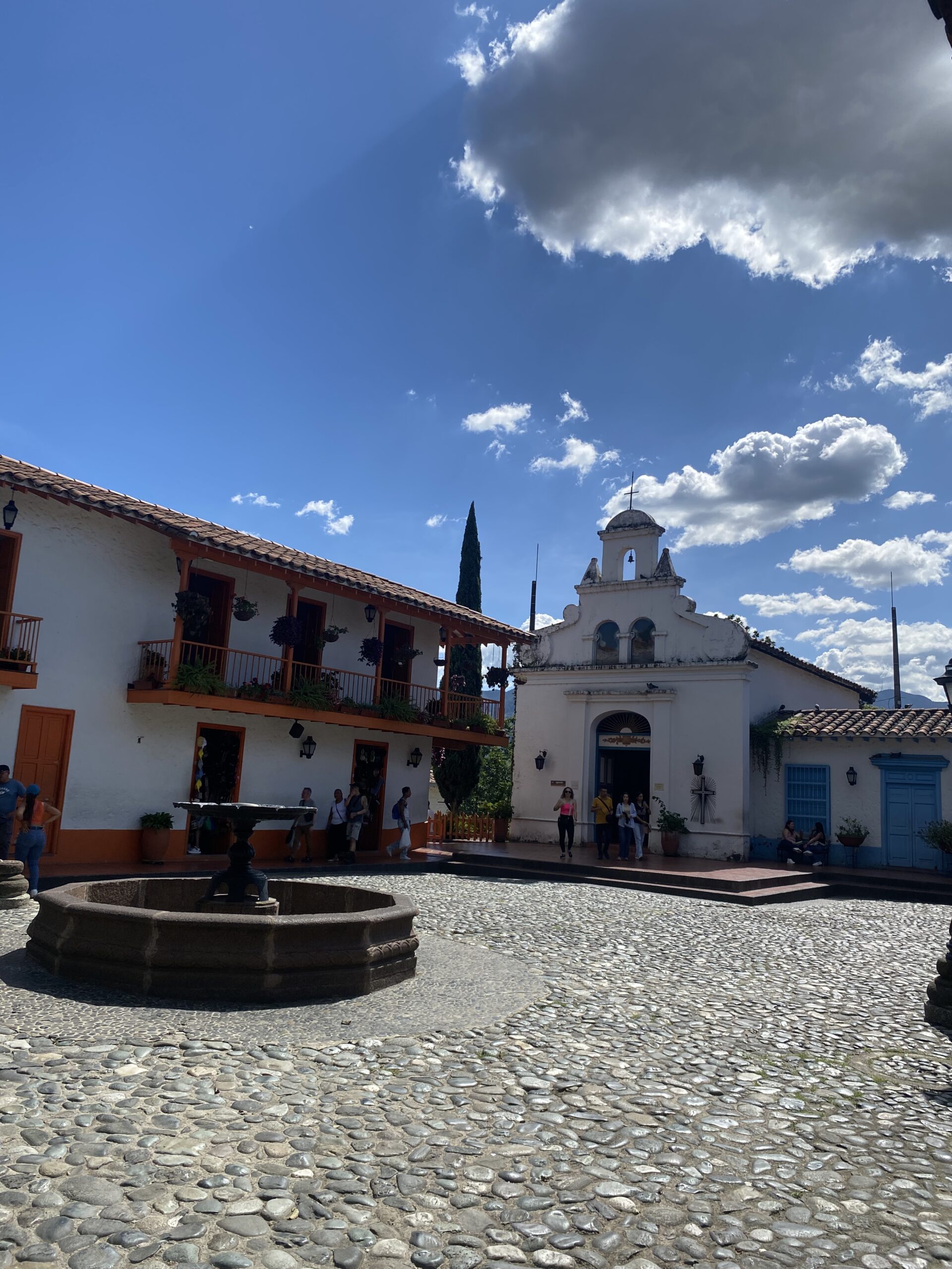 Carrer amb cases colonials i una església al centre de Medellín.