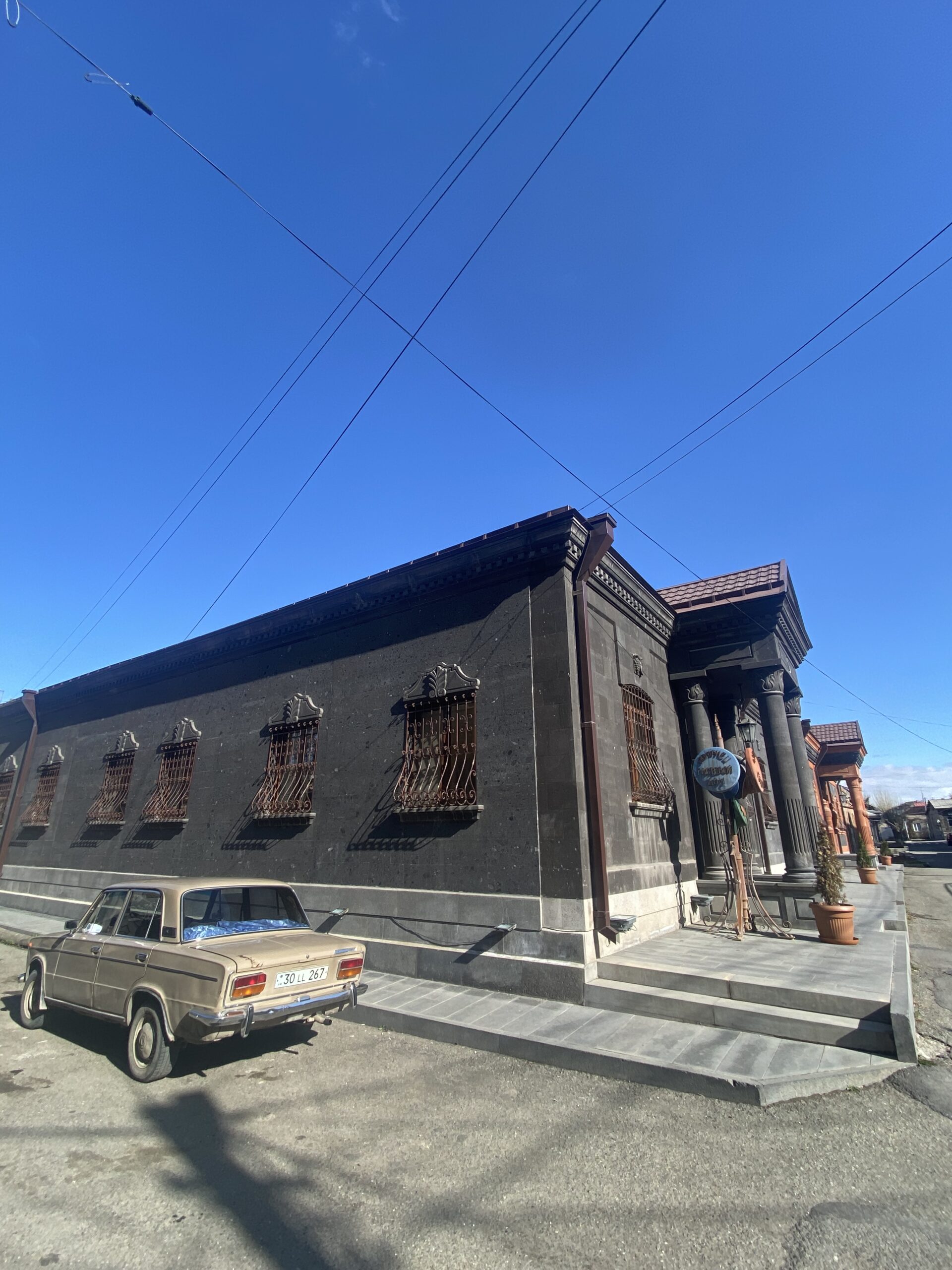 Edifici de pedra amb finestres arquejades, exemple de l'arquitectura de tuf típica del centre històric de Gyumri