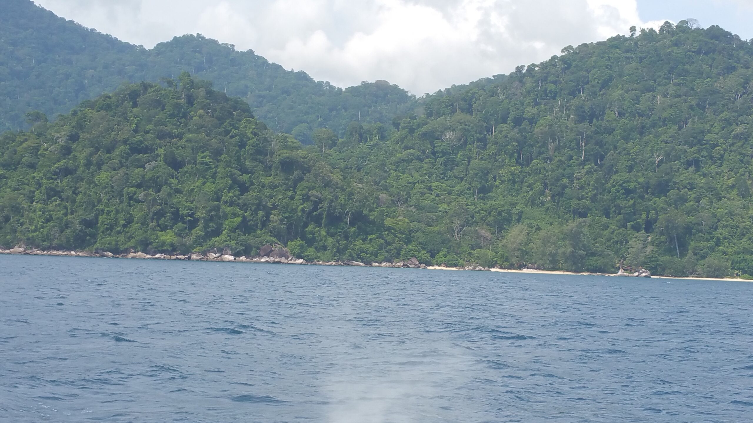 Costa muntanyosa coberta de selva vista des del mar a l'illa de Tioman, Malàisia