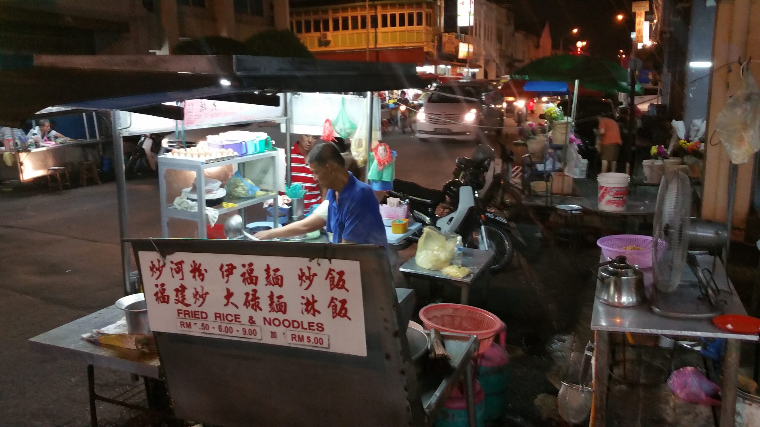 Venedor preparant menjar en una parada nocturna de George Town, Penang, Malàisia