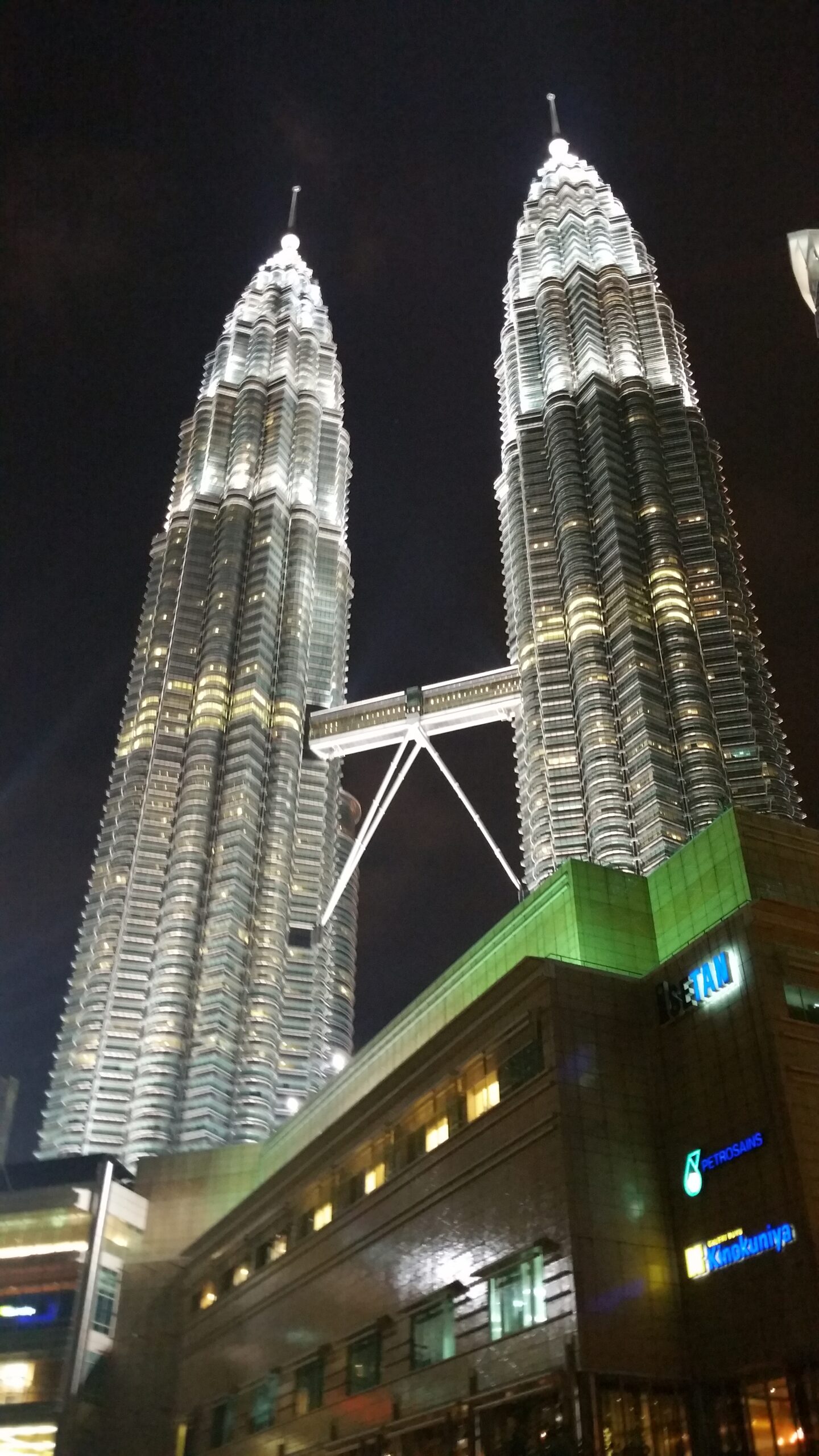 Torres Petronas il·luminades de nit amb el pont Skybridge a Kuala Lumpur