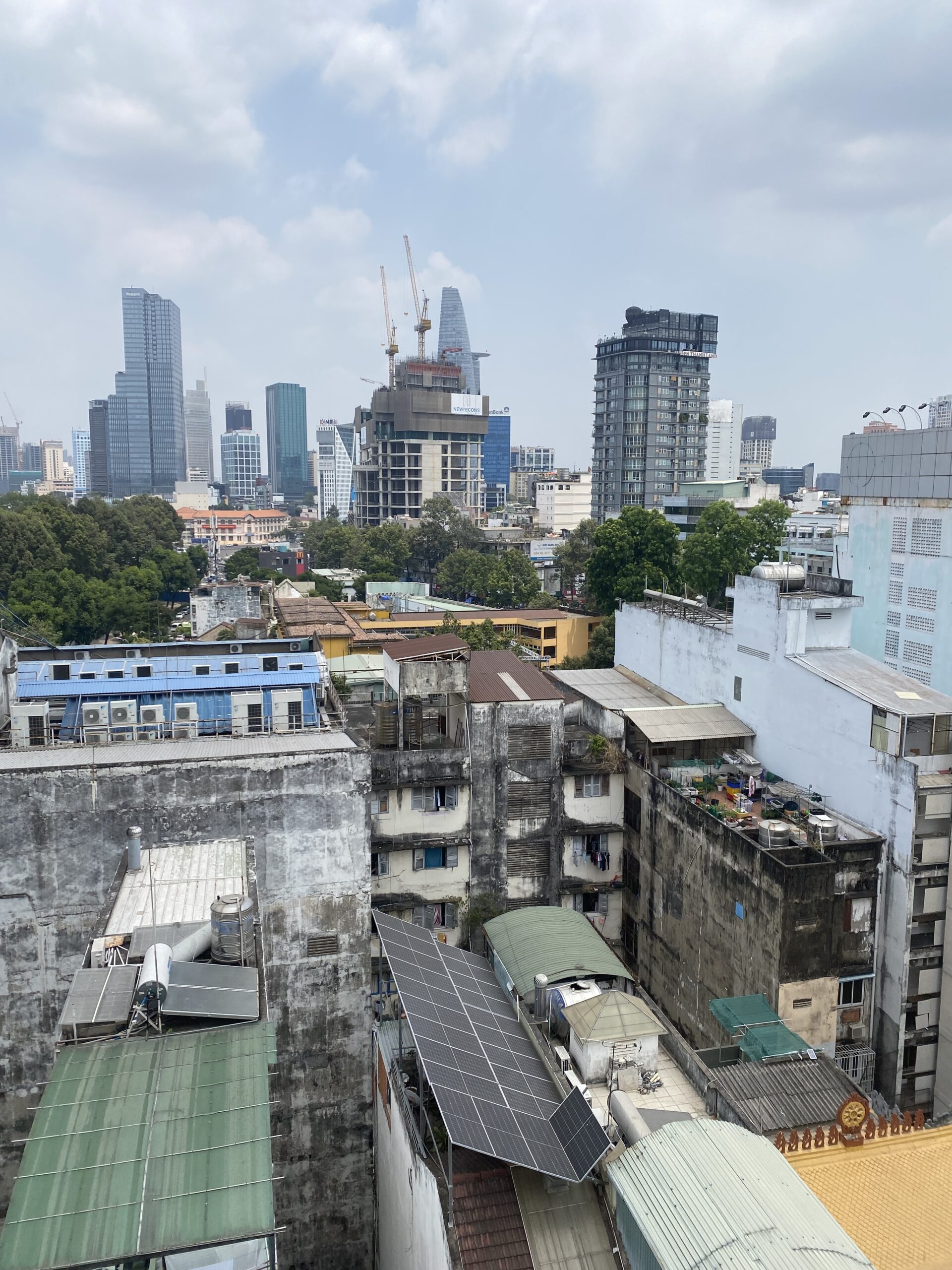 Vista de l'skyline modern de Ho Chi Minh amb gratacels i teulades antigues en primer terme, Vietnam