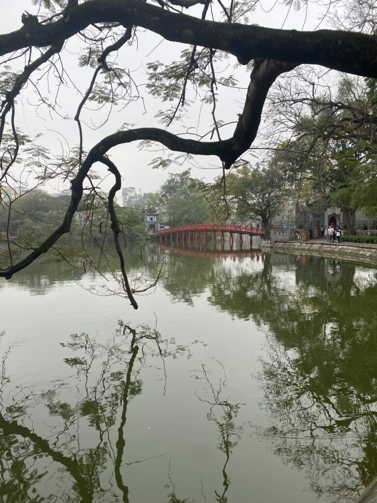 El pont vermell del Temple Ngoc Son vist entre les branques al llac Hoan Kiem, Hanoi