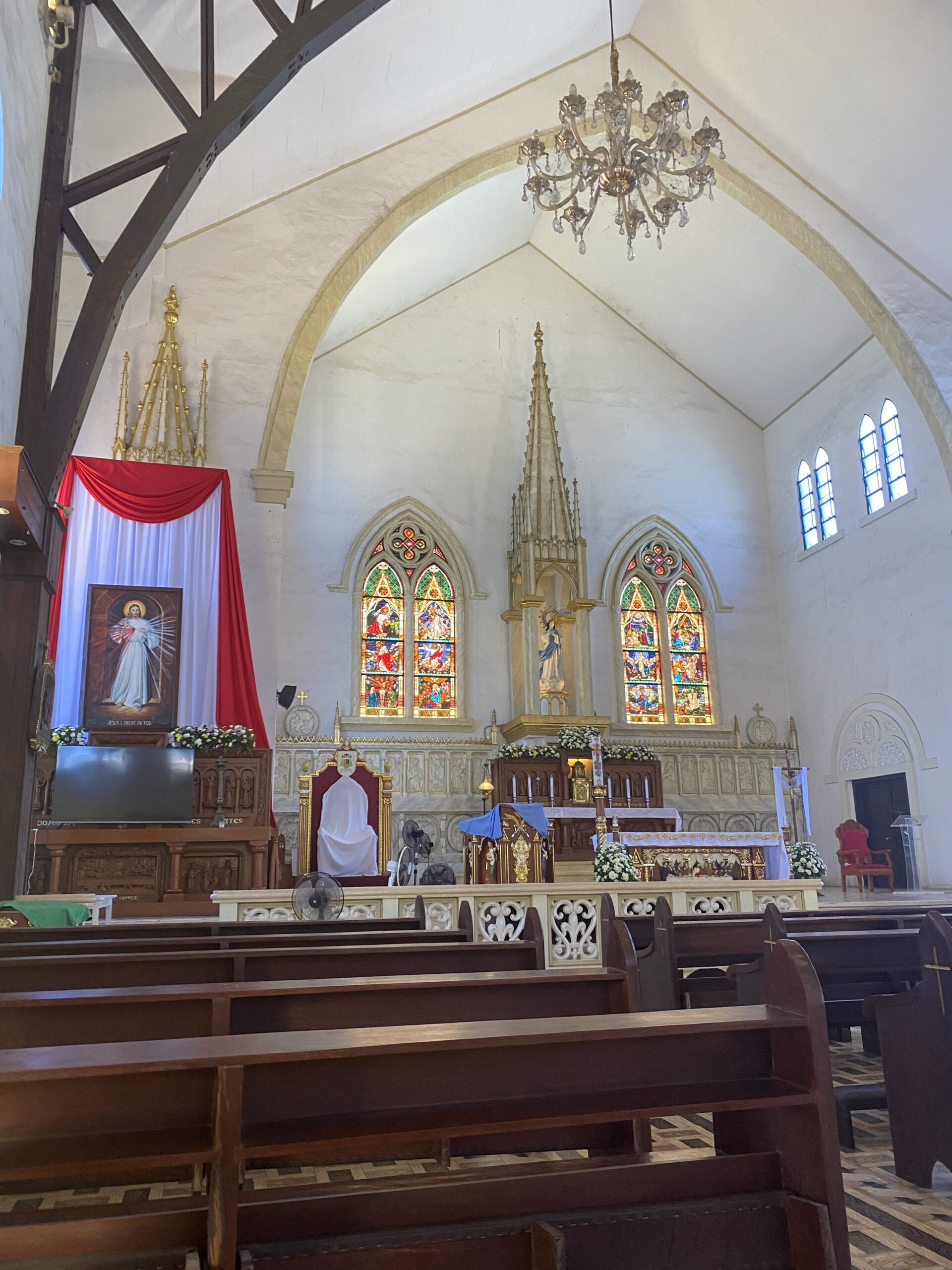 Interior de la Catedral de la Immaculada Concepció de Puerto Princesa amb vitralls i altar central.