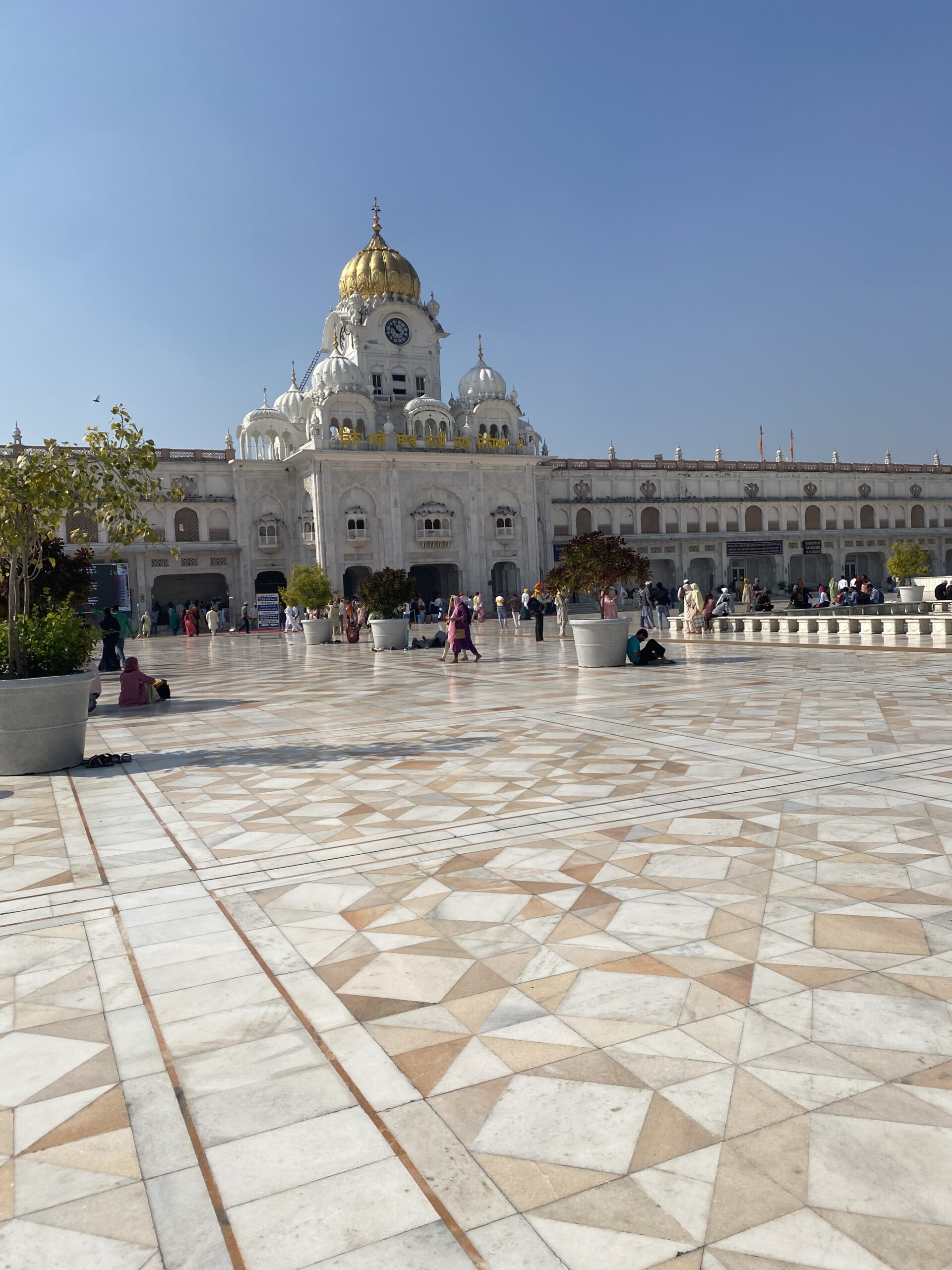 Edifici religiós blanc amb cúpules daurades dins del complex del Temple Daurat d'Amritsar.