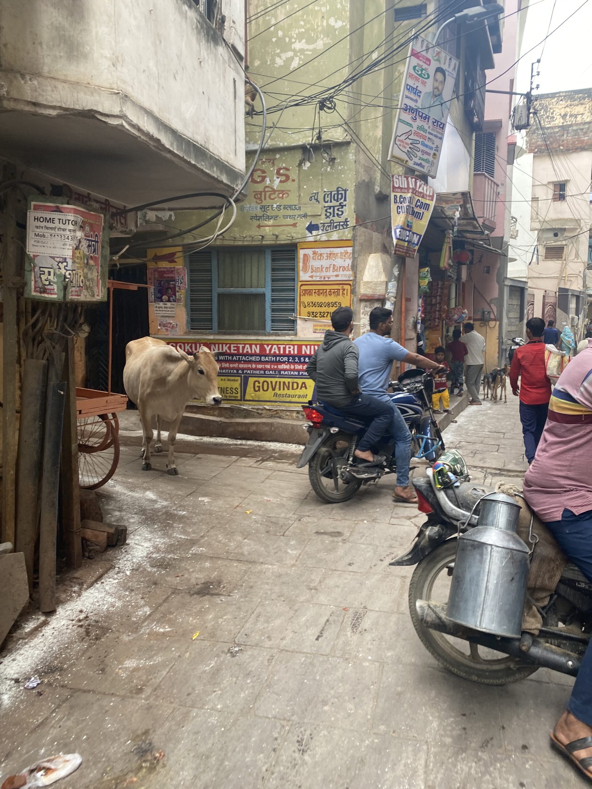 Trànsit, motocicletes, comerços i vida quotidiana en un carrer del centre de Varanasi, Índia.