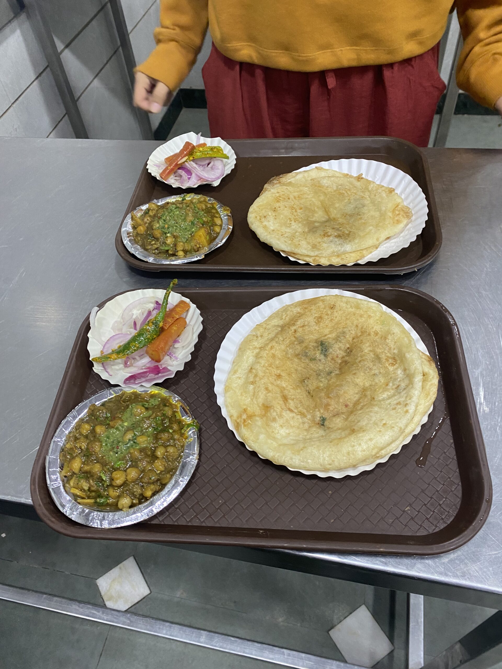 Safata amb pa fregit indi, curri i diferents acompanyaments servida a Delhi, Índia