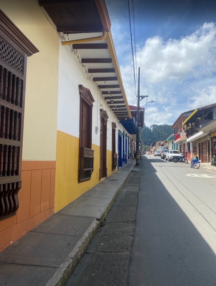 Carrer del centre històric de Jardín amb cases de colors i les muntanyes d'Antioquia al fons