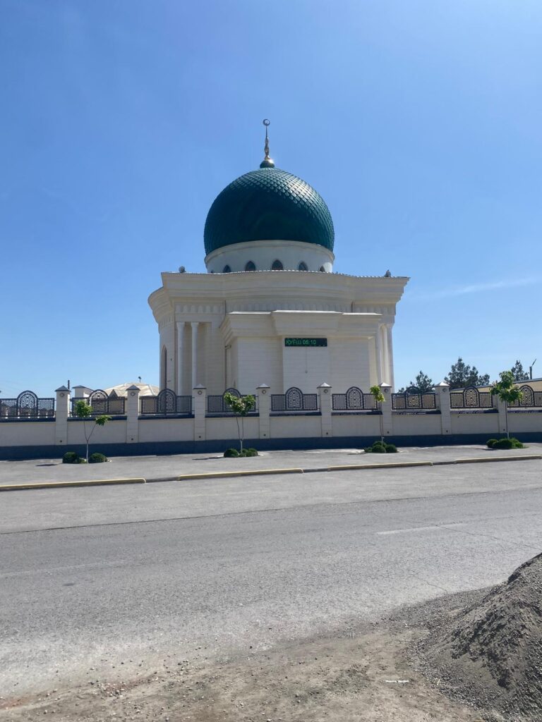 Mesquita blanca amb gran cúpula verda sota un cel clar a Margilan, Uzbekistan