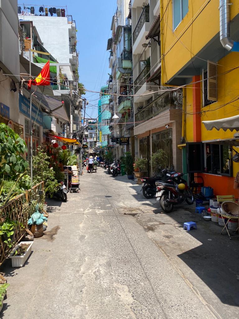 Carreró residencial a Ho Chi Minh Carreró estret amb façanes de colors i roba estesa en un barri residencial de Ho Chi Minh, Vietnam