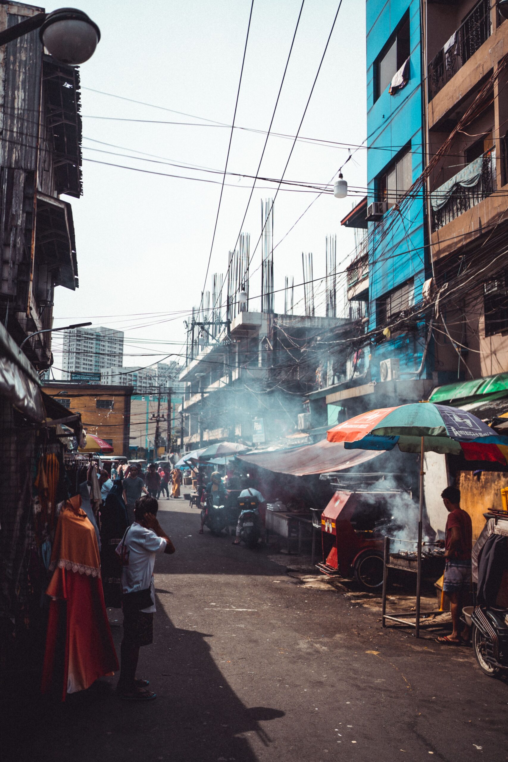Carrer dens de Manila amb habitatges, comerços, cables elèctrics i activitat quotidiana, Filipines.