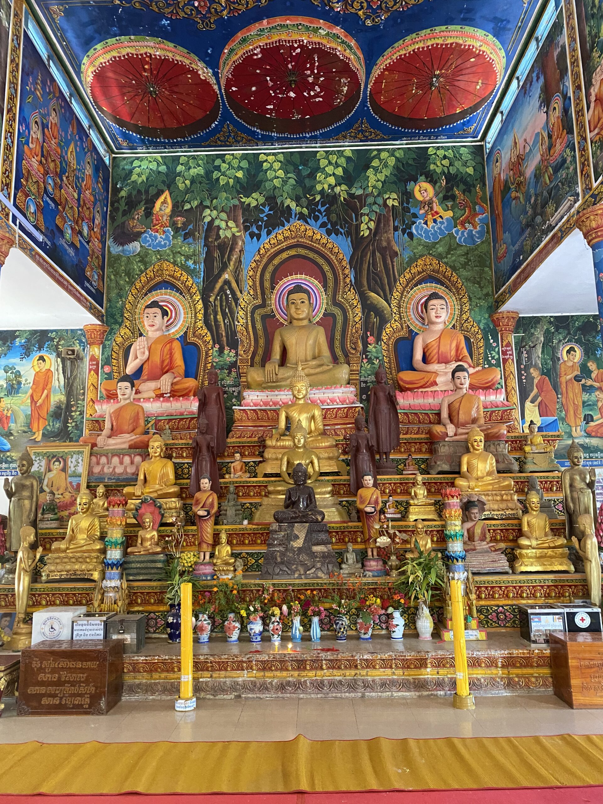 Interior d'un temple amb pintures murals i estàtues de Buda a Kampot