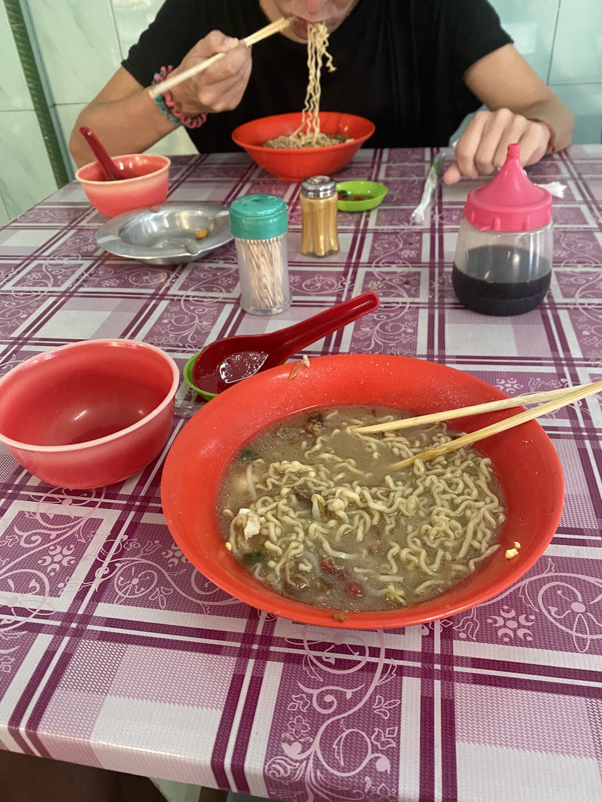 Bols de fideus i plats d'esmorzar en un local de Medan