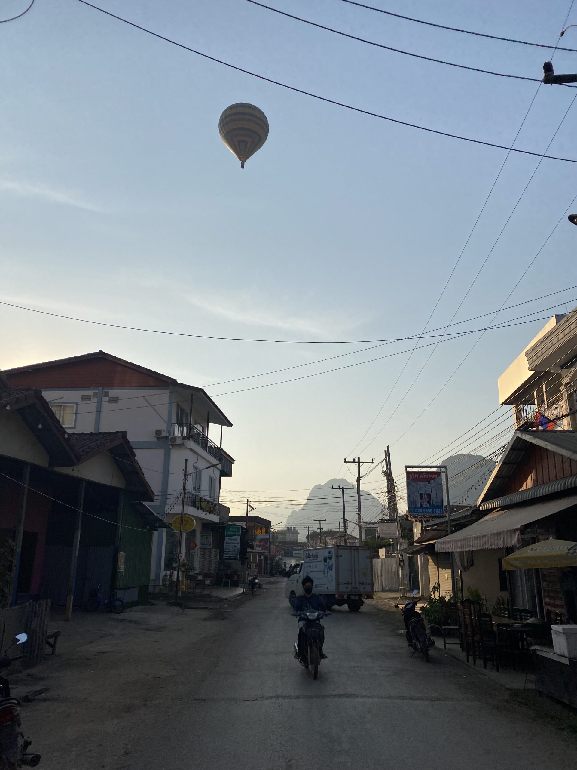 Carrer del centre de Vang Vieng amb les muntanyes càrstiques al fons