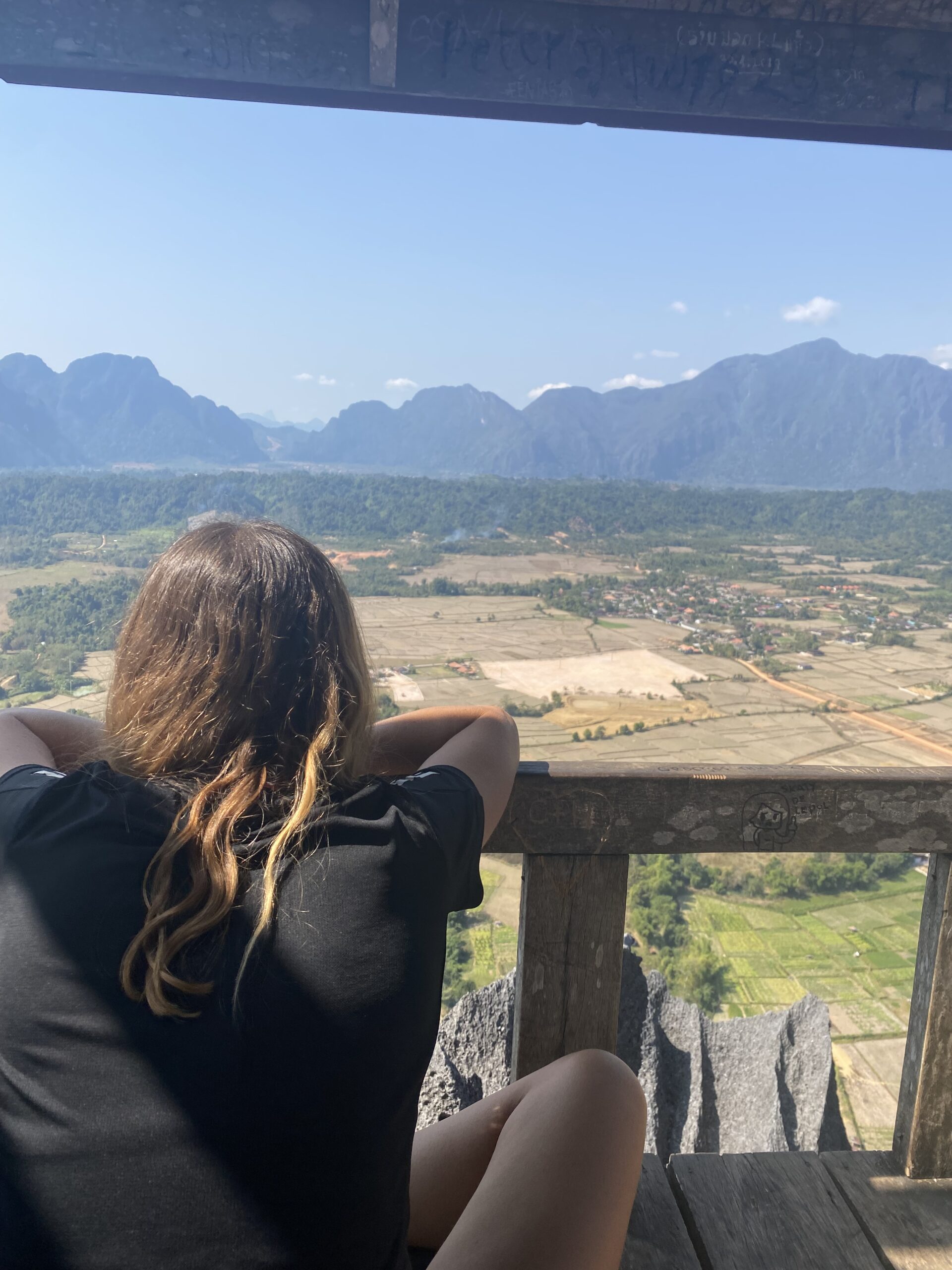 Viatgera contemplant la vall de Vang Vieng des d'un mirador