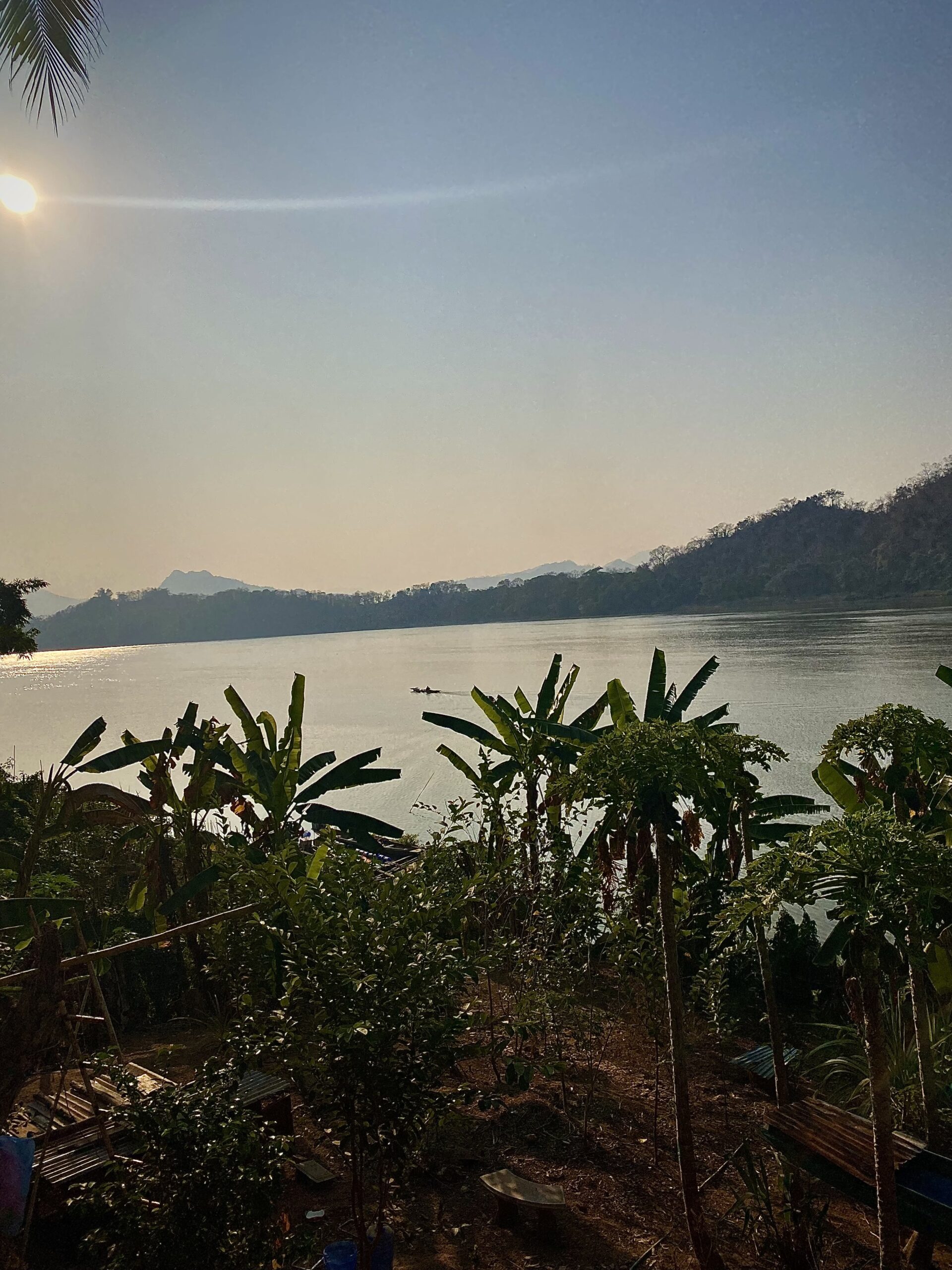 Posta de sol sobre el Mekong amb palmeres a la riba, a Luang Prabang