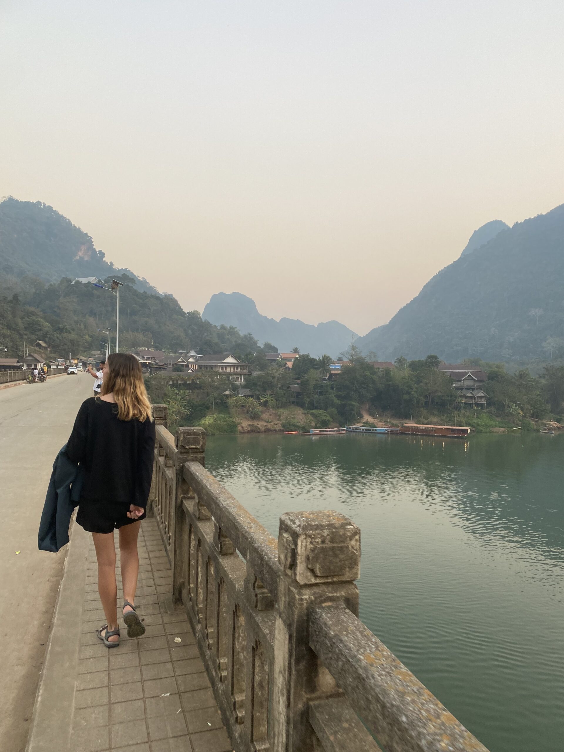 Viatgera al pont de Nong Khiaw mirant el riu Nam Ou al capvespre