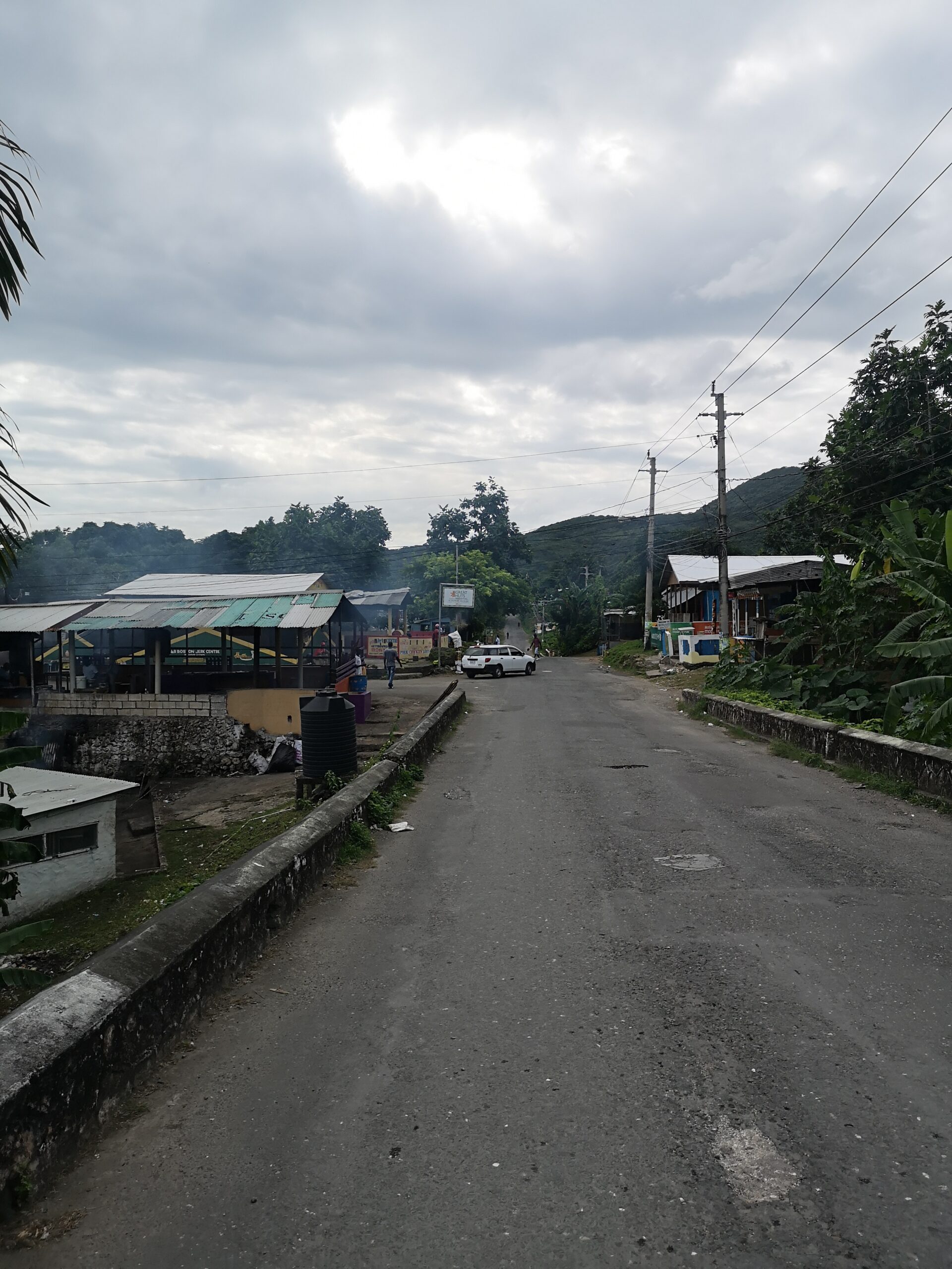 Carrer entre cases i turons verds a Portland, Jamaica