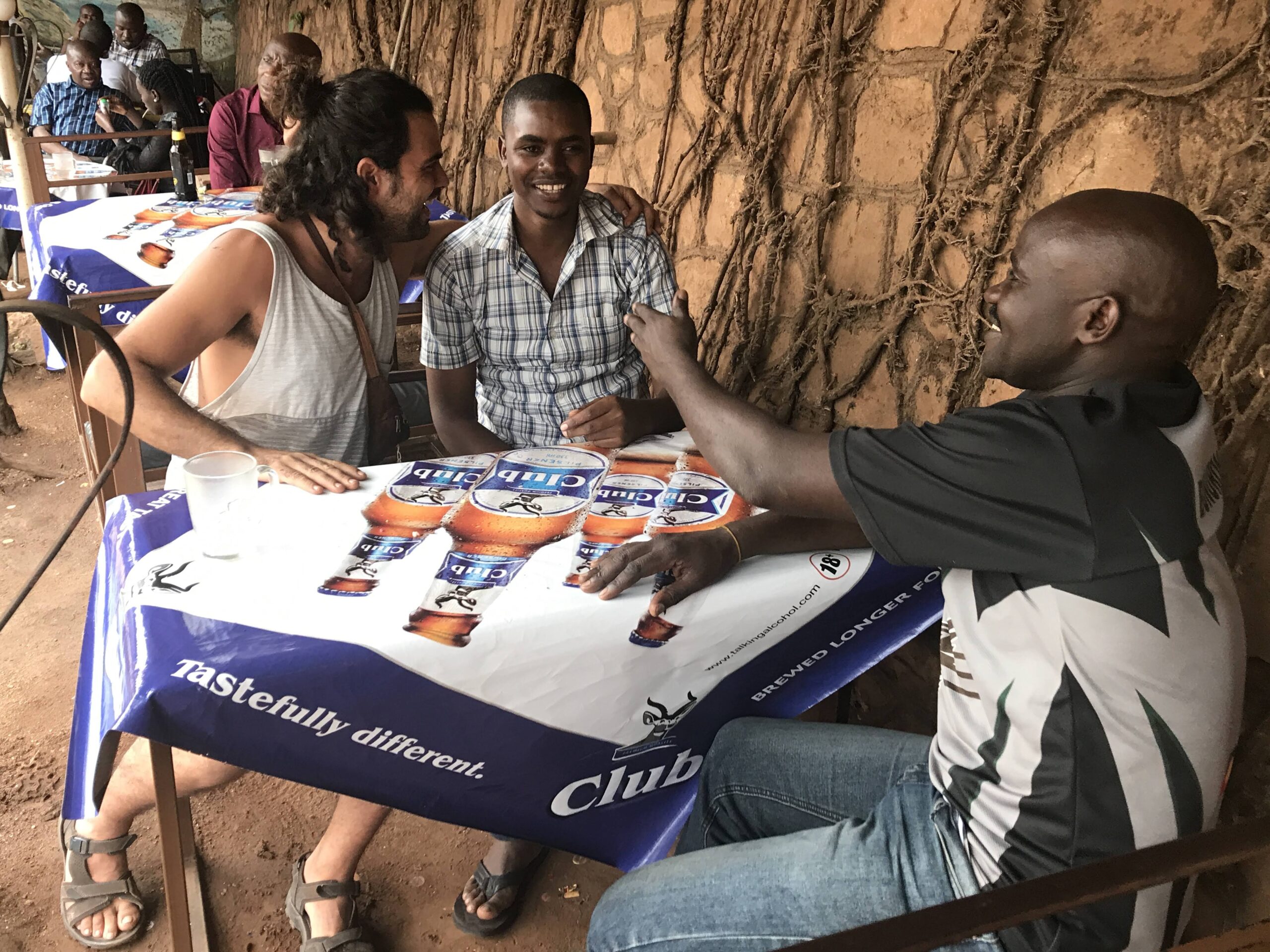 Gent conversant al voltant d'una parada al carrer al centre de Kampala