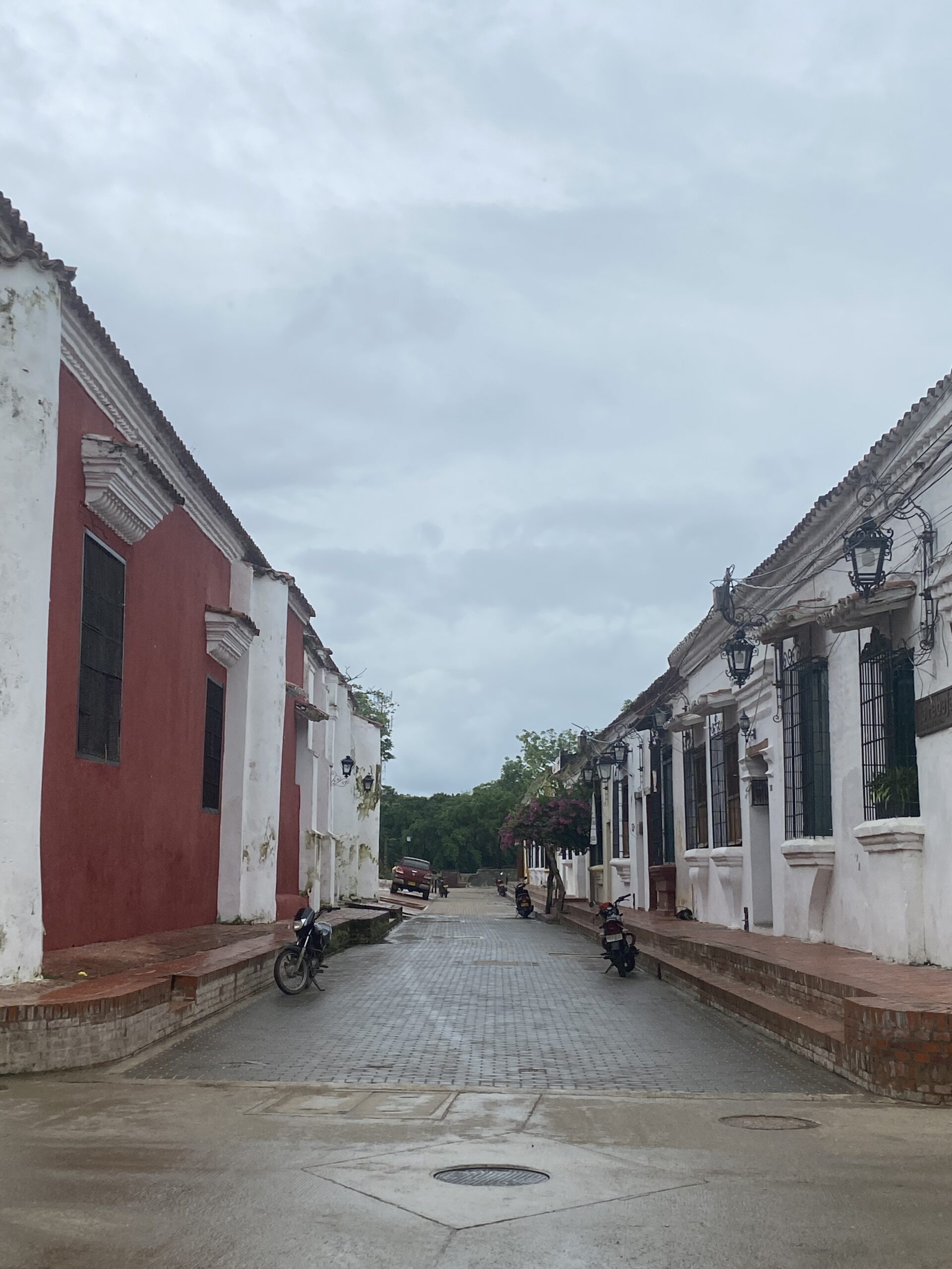 Carrer tranquil de Mompox amb cases colonials blanques i una façana vermella