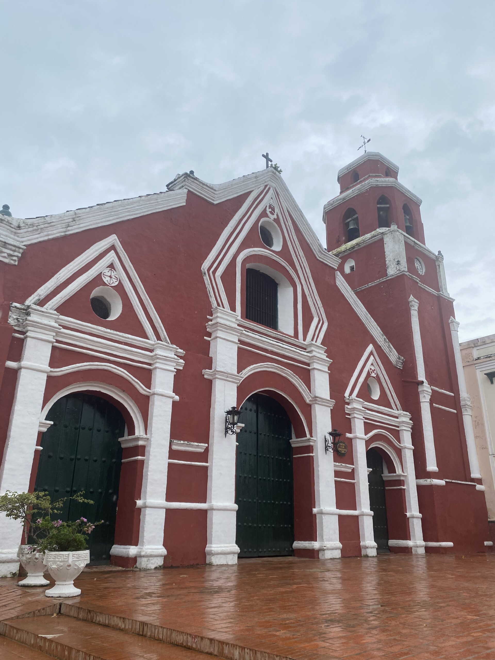 Façana vermella i blanca d'una església de Mompox amb una porta central i finestres altes