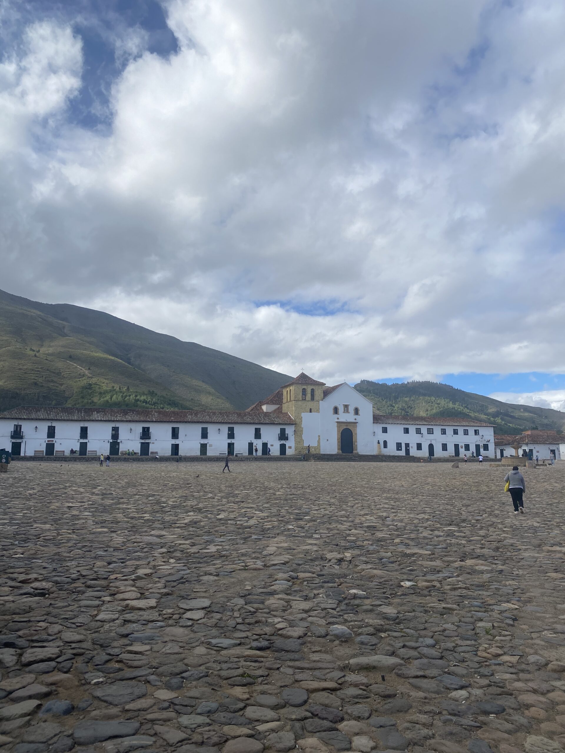 Plaza Mayor empedrada de Villa de Leyva amb l'església al fons i les muntanyes de Boyacá
