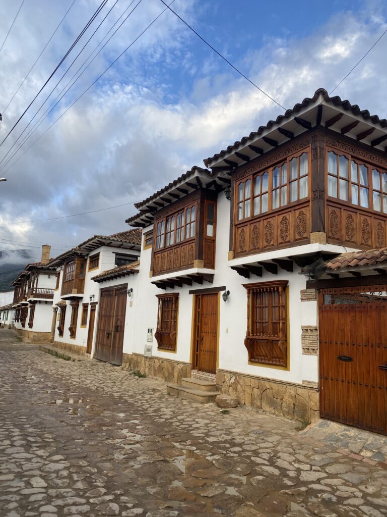 Casa colonial blanca amb balcons de fusta en una cantonada empedrada de Villa de Leyva