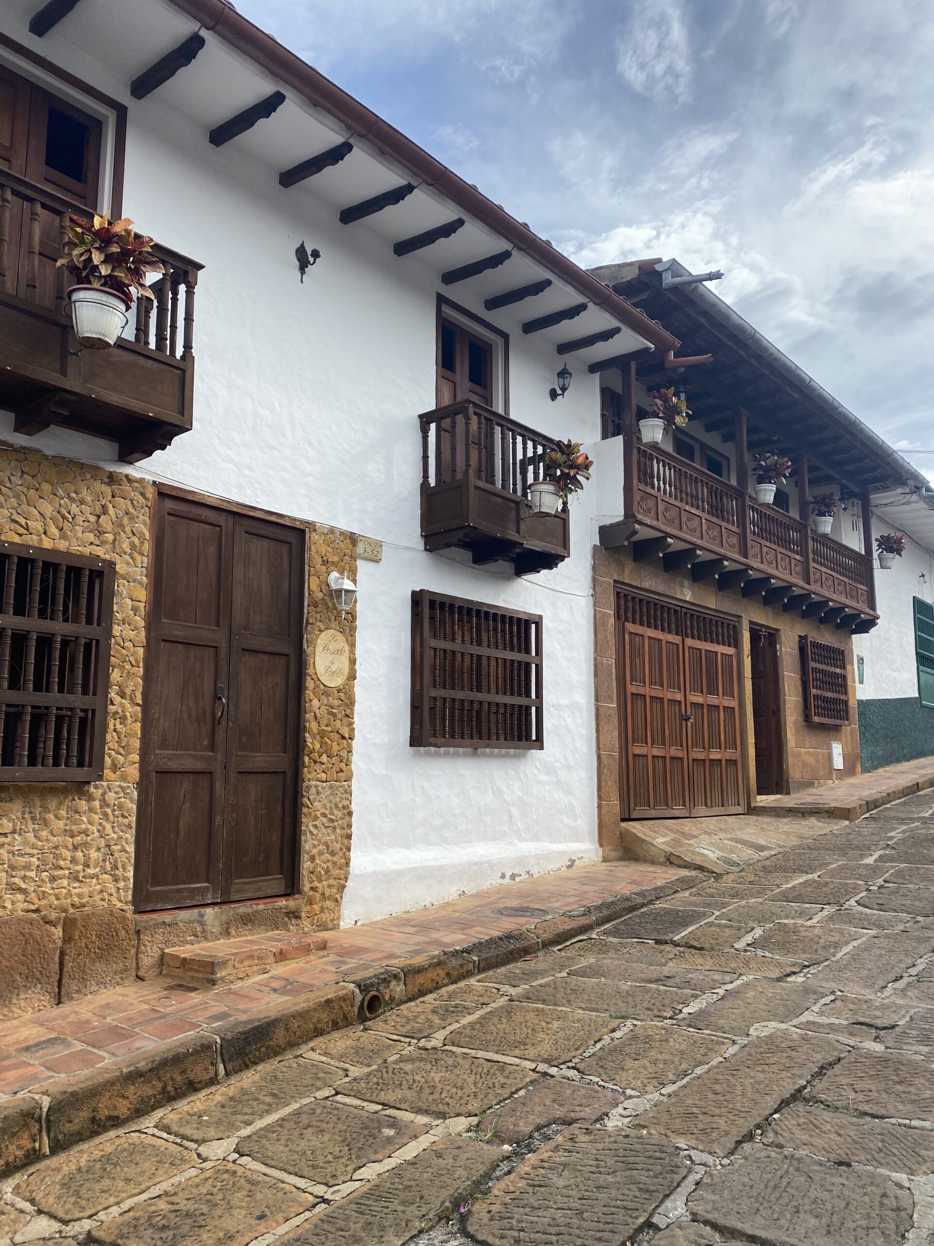 Façana blanca d'una casa de Barichara amb balcó de fusta, porta antiga i teulada de teula