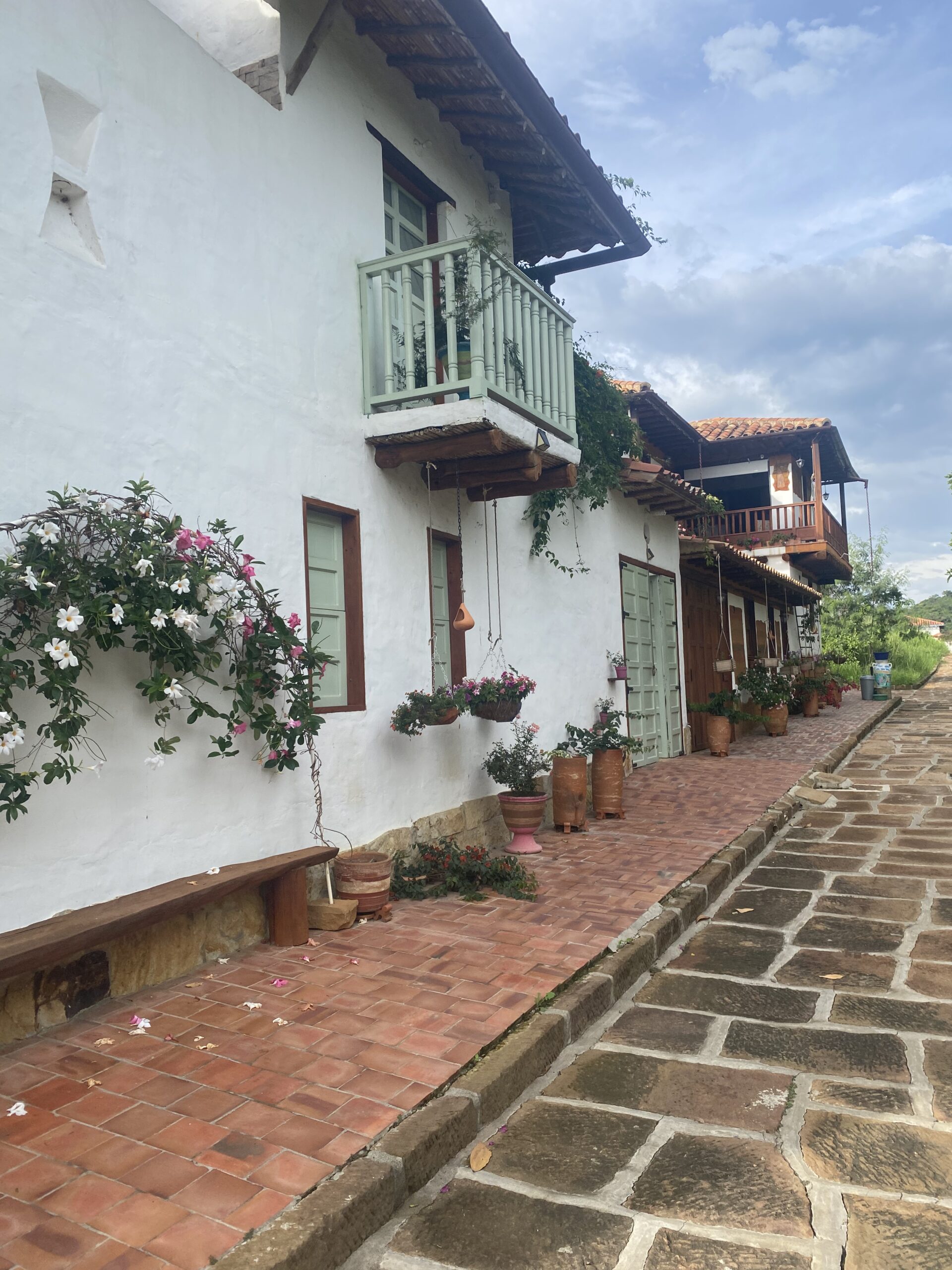 Carrer tranquil de Barichara amb cases blanques, balcons i flors a les façanes