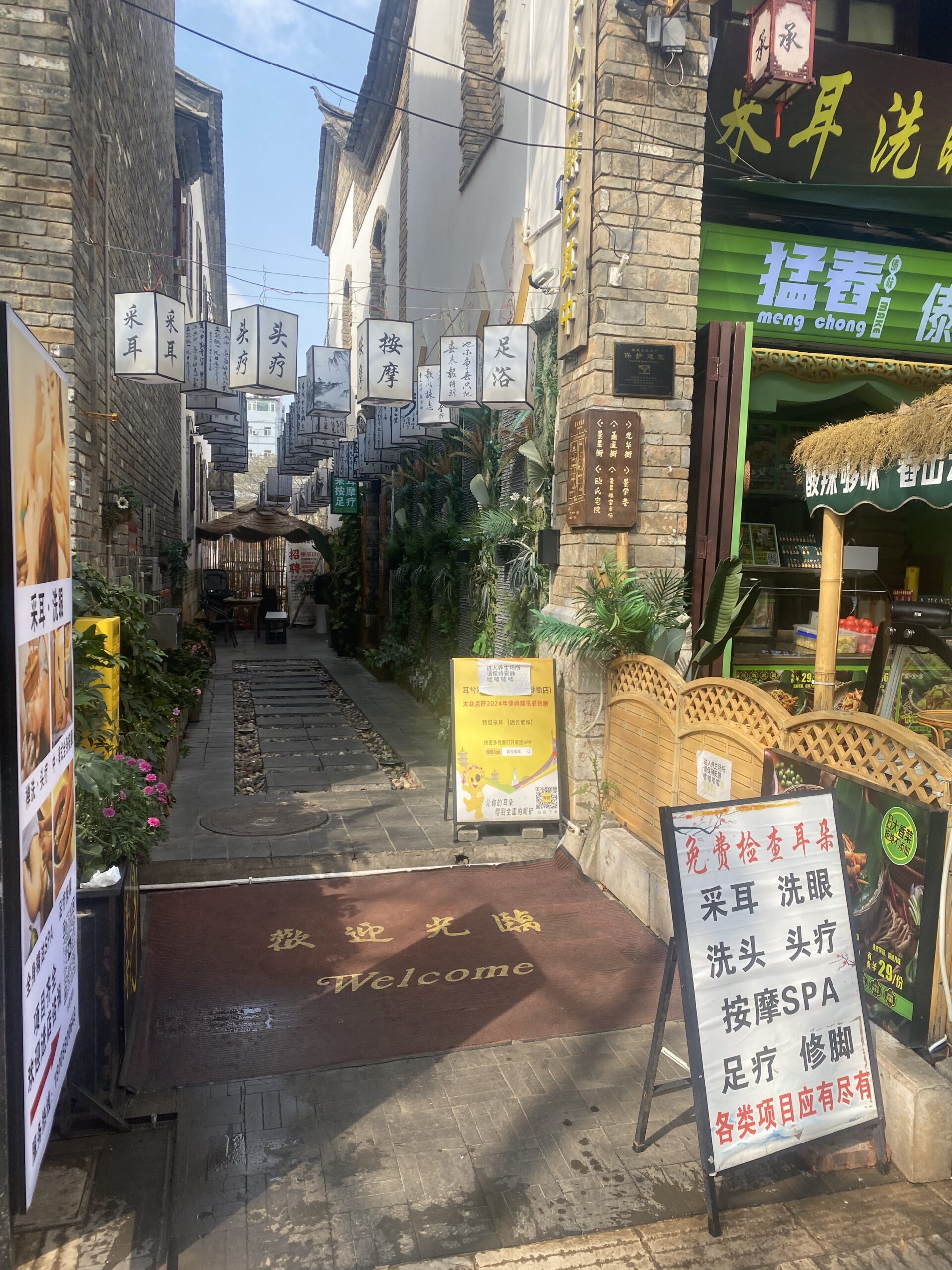 Carreró estret amb rètols en xinès i botigues al centre de Kunming
