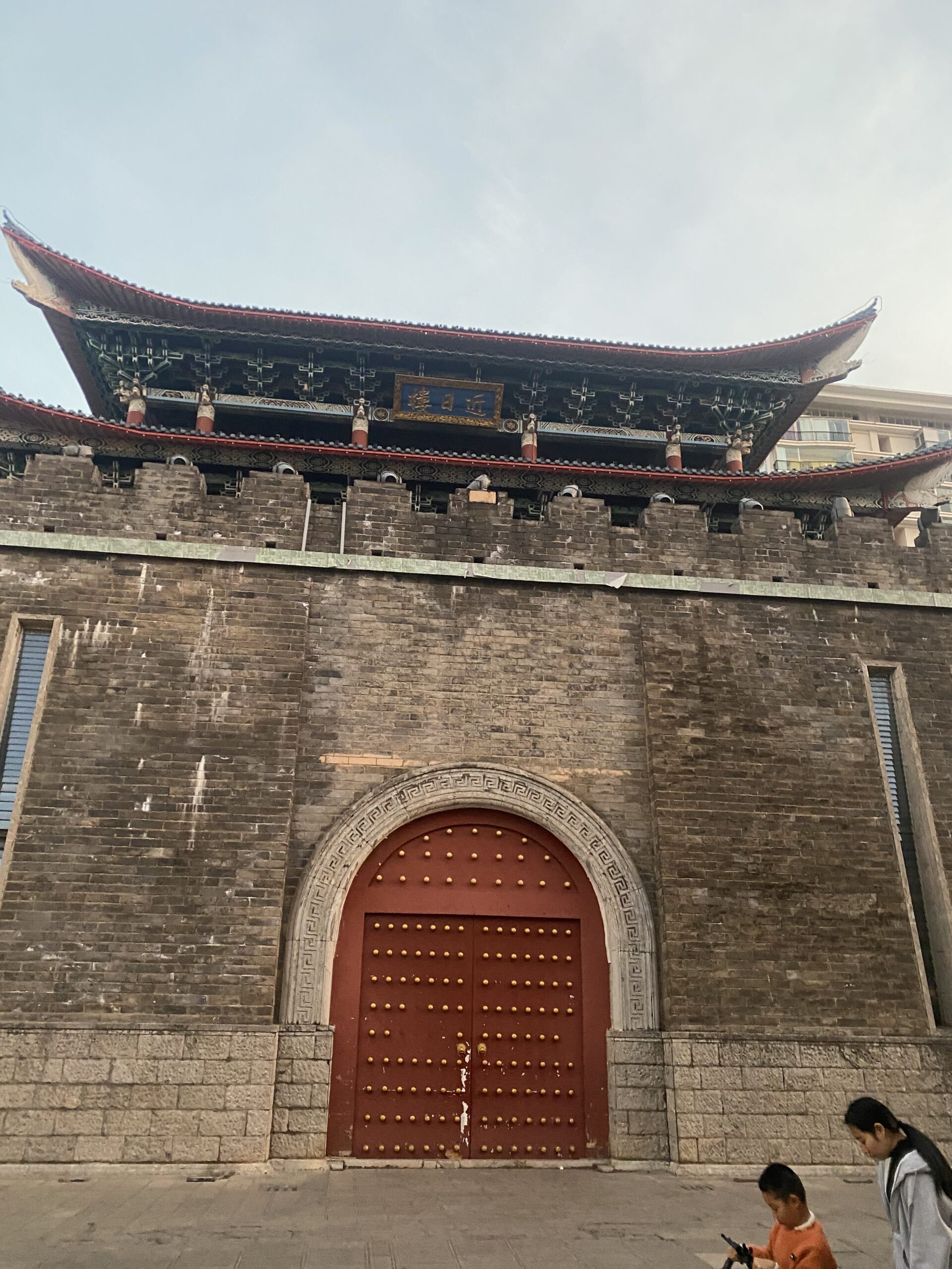 Torre de porta tradicional amb teulada corbada sobre una muralla de maó a Kunming