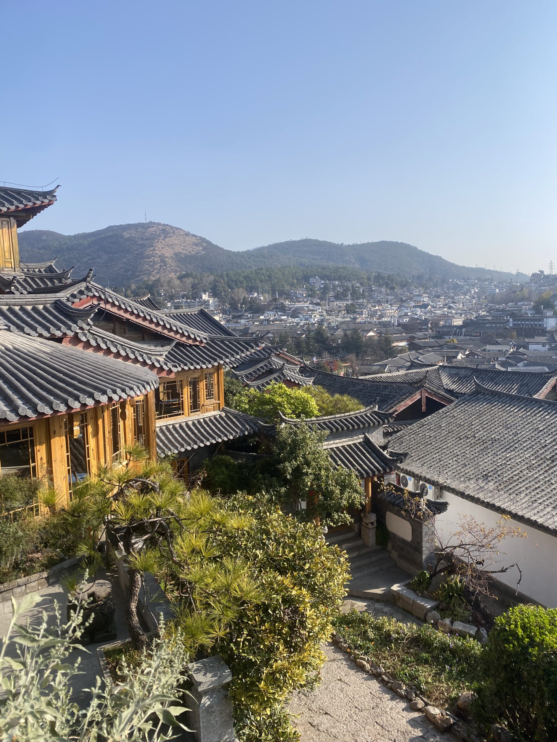 Vista de les teulades del nucli antic de Lijiang amb les muntanyes al fons