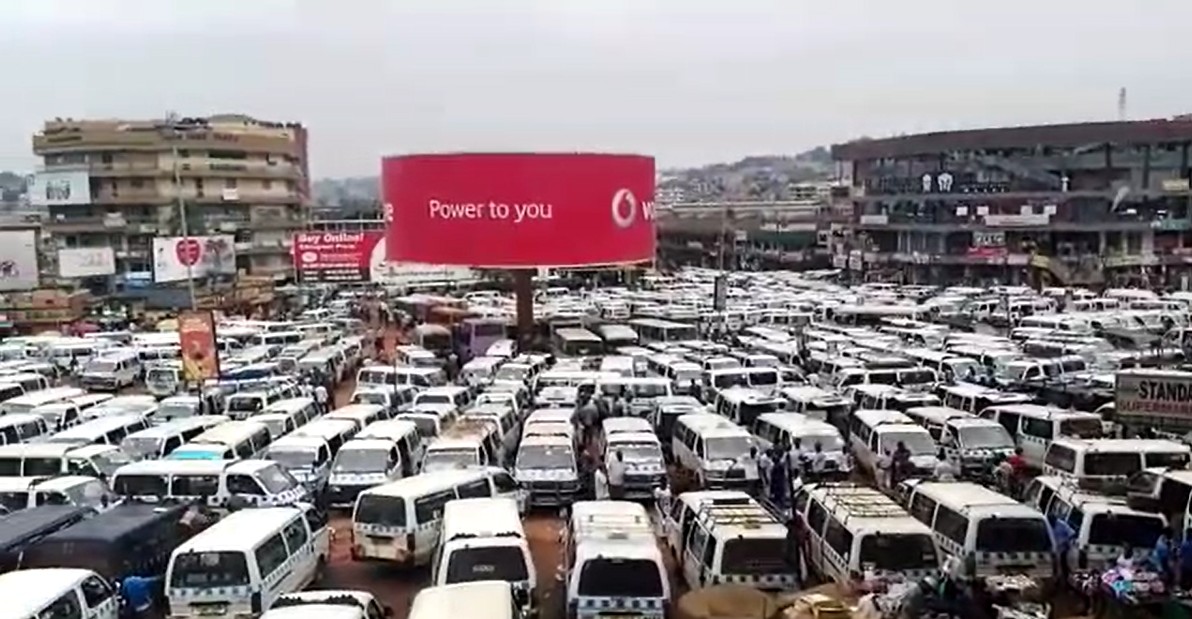 Centenars de minibusos blancs i blaus aparcats en un taxi park de Kampala, Uganda