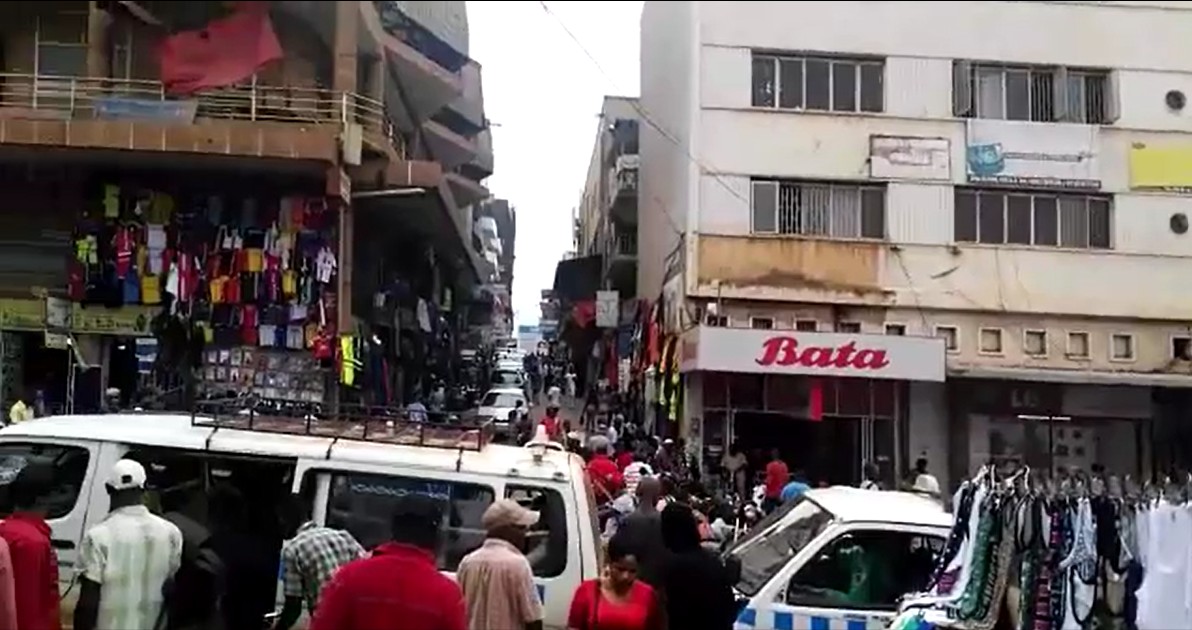 Carrer ple de gent i de minibusos al costat dels mercats del centre de Kampala